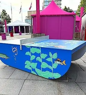 Ett pingisbord på torget med ett målat havsmotiv.